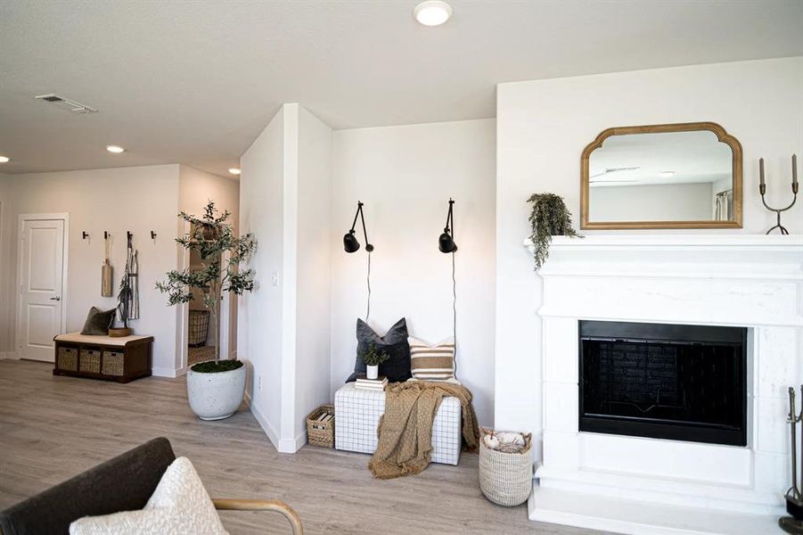 Living room with a fireplace, recessed lighting, and wood finished floors Living room with a fireplace, recessed lighting, and wood finished floors