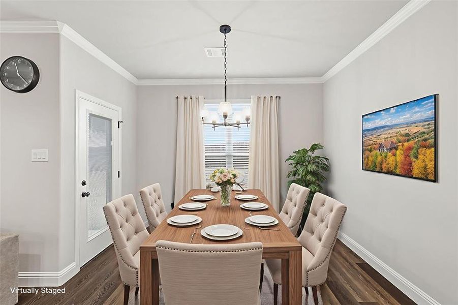 VIRTUALLY STAGED Dining space with ornamental molding, dark wood finished floors, and a chandelier