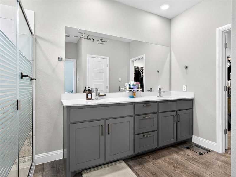 Dual vanity with gray cabinetry and white countertops Dual vanity with gray cabinetry and white countertops