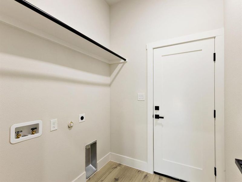 Laundry area with hookup for a gas dryer, light wood finished floors, hookup for a washing machine, and electric dryer hookup