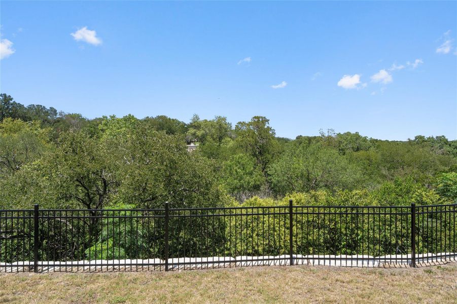 A tranquil, fenced yard offers a serene view of lush, verdant trees under a clear sky. A tranquil, fenced yard offers a serene view of lush, verdant trees under a clear sky.
