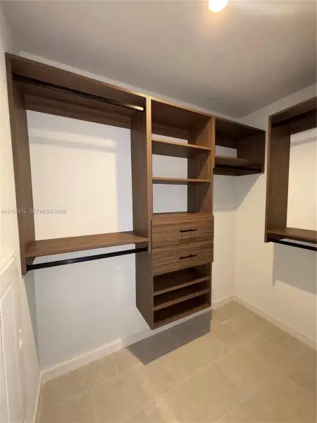 Custom closet organization system featuring wood-finish shelving, integrated drawers with matte black hardware, and dual hanging rods Custom closet organization system featuring wood-finish shelving, integrated drawers with matte black hardware, and dual hanging rods