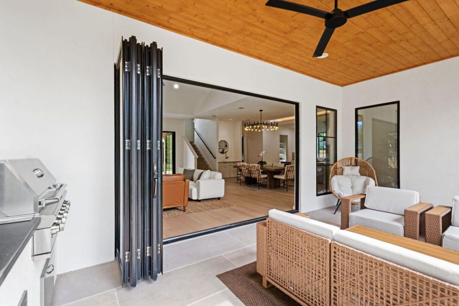 An inviting outdoor patio features an outdoor grill and expansive folding doors, seamlessly connecting to indoor living. An inviting outdoor patio features an outdoor grill and expansive folding doors, seamlessly connecting to indoor living.