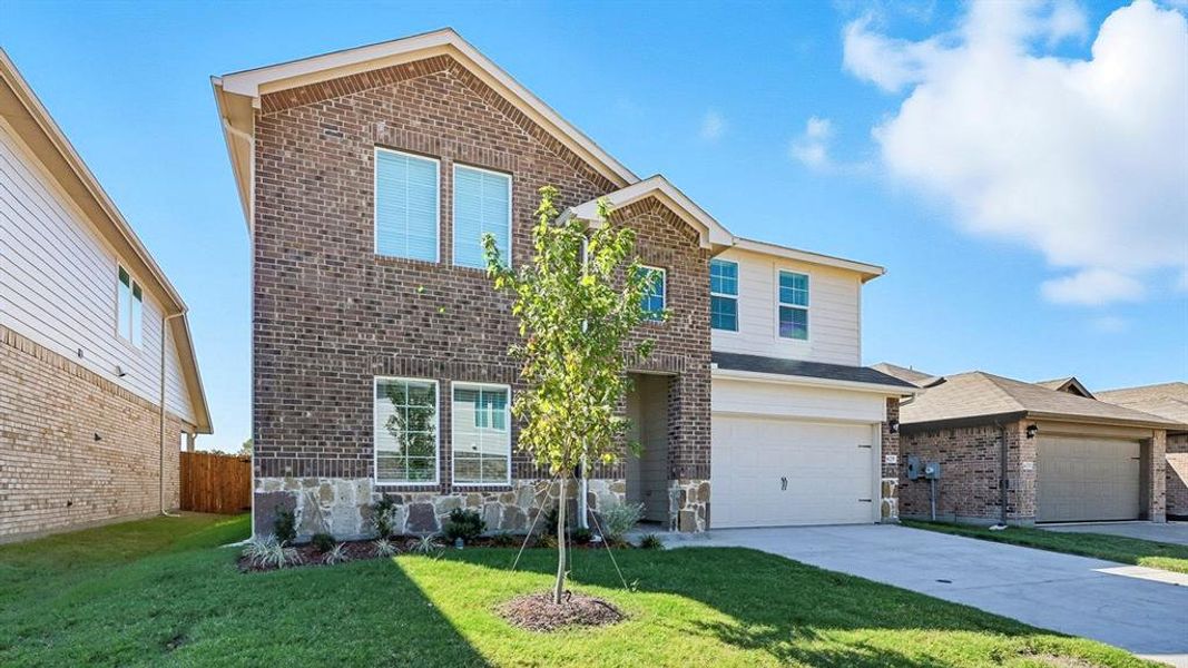 Traditional home with brick siding, concrete driveway, and a garage