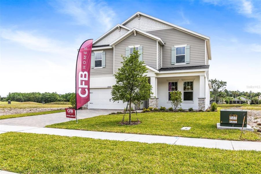 Front exterior of a new home in Gray Hawk at Hole Two, Daytona Beach, FL, highlighting curb appeal (Image 26). Front exterior of a new home in Gray Hawk at Hole Two, Daytona Beach, FL, highlighting curb appeal (Image 26).