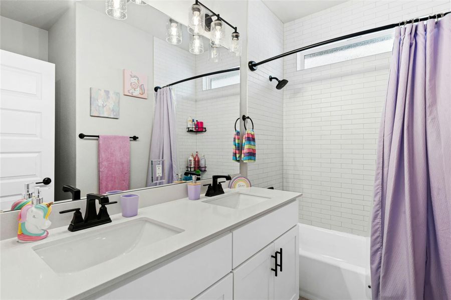 Full bathroom featuring double vanity and shower / tub combo