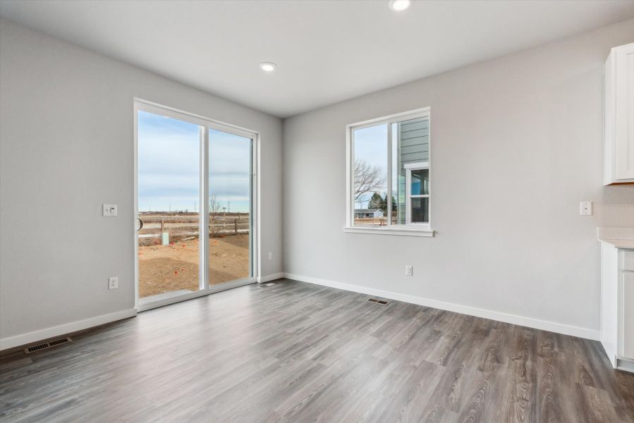 A room with a wood floor and a large window.