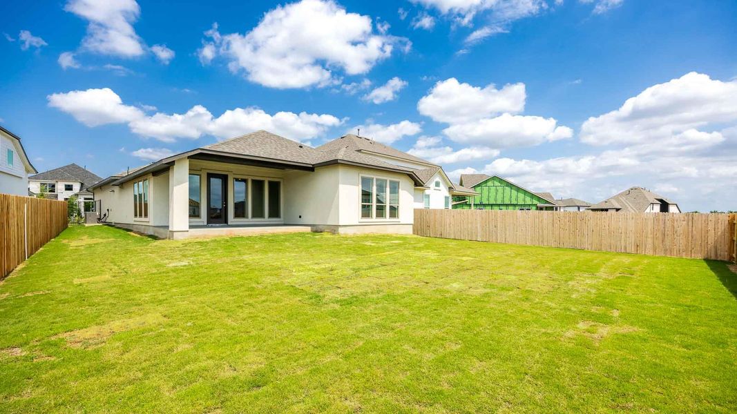 Rear view of property featuring a yard, stucco siding, and a fenced backyard Rear view of property featuring a yard, stucco siding, and a fenced backyard