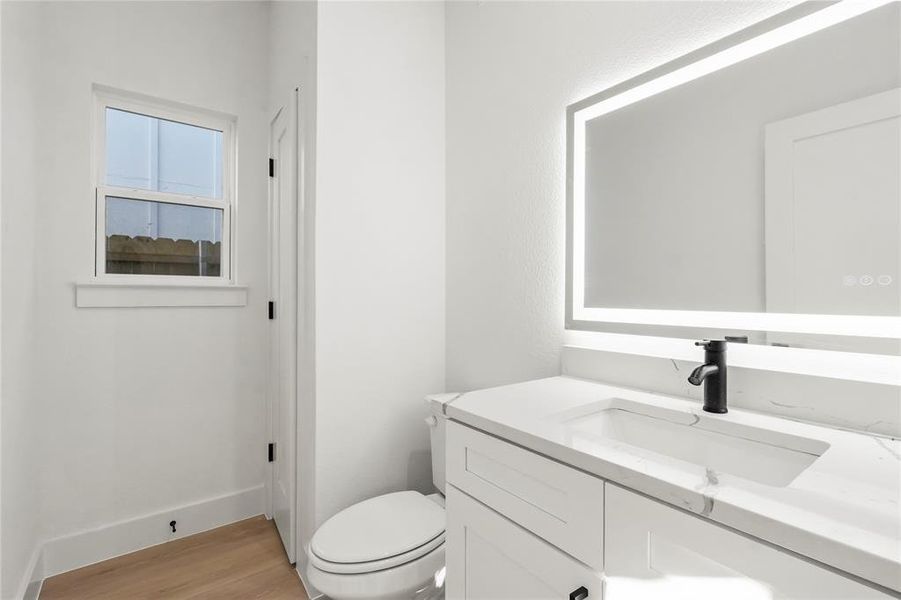 Half bathroom featuring vanity and light wood finished floors