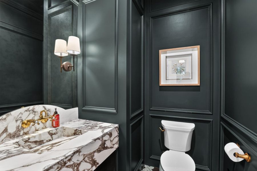 Marble-clad vanity and panel-molded walls define this distinctive powder room. Marble-clad vanity and panel-molded walls define this distinctive powder room.