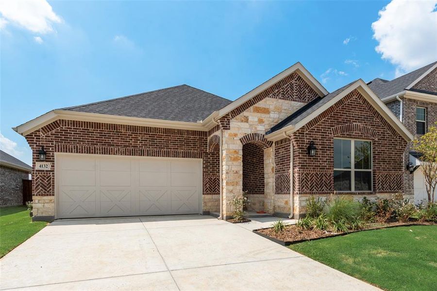 Front exterior of a new home in Spiritas Ranch, Little Elm, TX, highlighting curb appeal (Image 17). Front exterior of a new home in Spiritas Ranch, Little Elm, TX, highlighting curb appeal (Image 17).