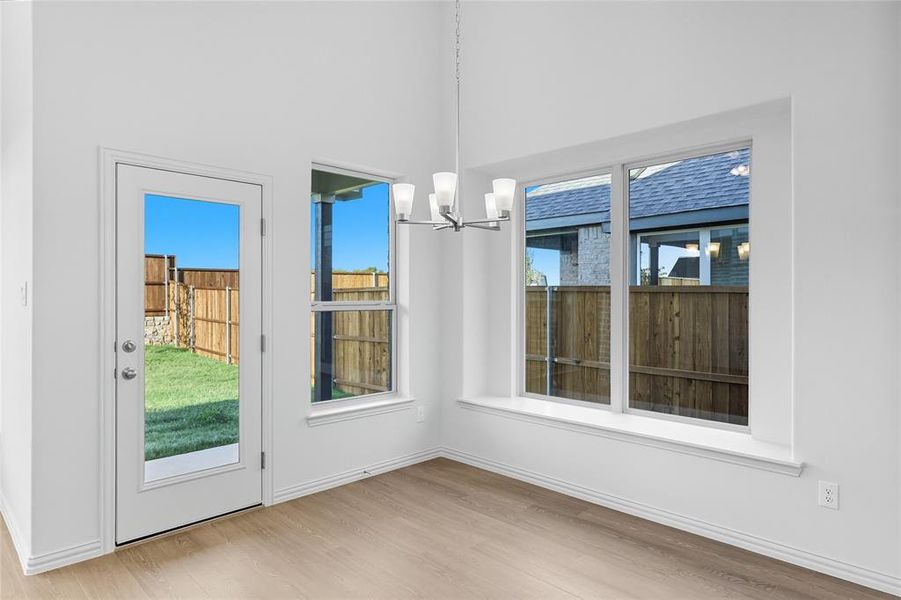 Unfurnished dining area with light wood finished floors and a chandelier Unfurnished dining area with light wood finished floors and a chandelier