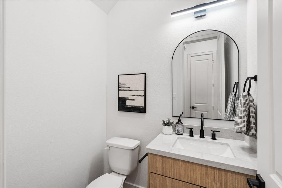 A refined half-bath featureswarm textures and modernfixtures — an elegant reflectionof the home’s overall designethos.