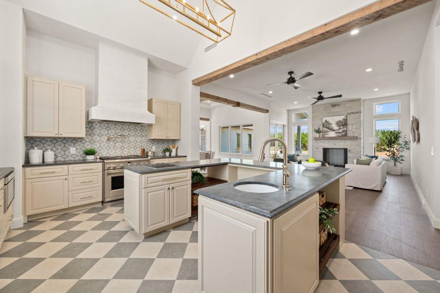 Kitchen with cream cabinetry, tasteful backsplash, a large fireplace, open floor plan, and beamed ceiling