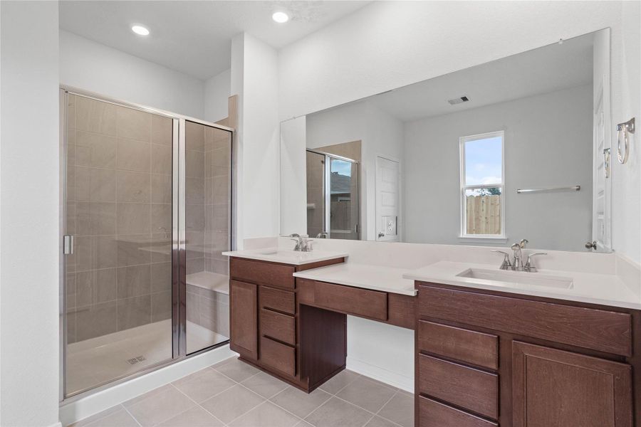 This beautifully updated primary bathroom is move-in ready! It showcases a large walk-in shower with seat and tile surround, stained cabinetry paired with light countertops, dual vanity sinks, a large mirror, high ceilings, custom paint, and stylish modern finishes throughout. This beautifully updated primary bathroom is move-in ready! It showcases a large walk-in shower with seat and tile surround, stained cabinetry paired with light countertops, dual vanity sinks, a large mirror, high ceilings, custom paint, and stylish modern finishes throughout.