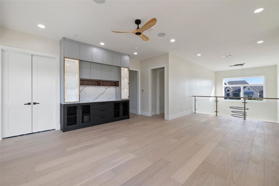 Unfurnished living room featuring ceiling fan and light hardwood / wood-style flooring