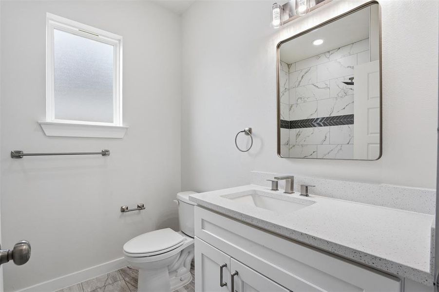 Bathroom featuring a single vanity with a white countertop, undermount sink, and brushed nickel fixtures