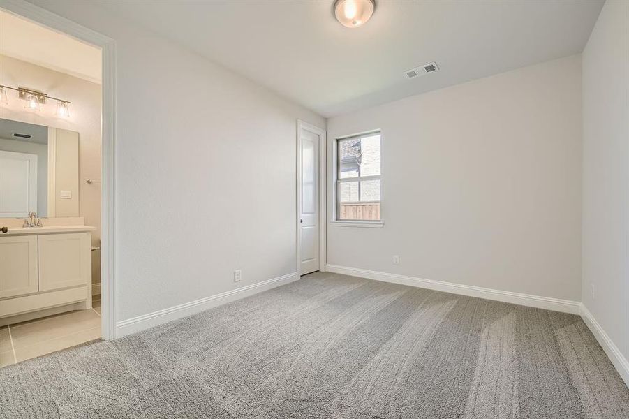 Unfurnished bedroom featuring carpet and ensuite bathroom