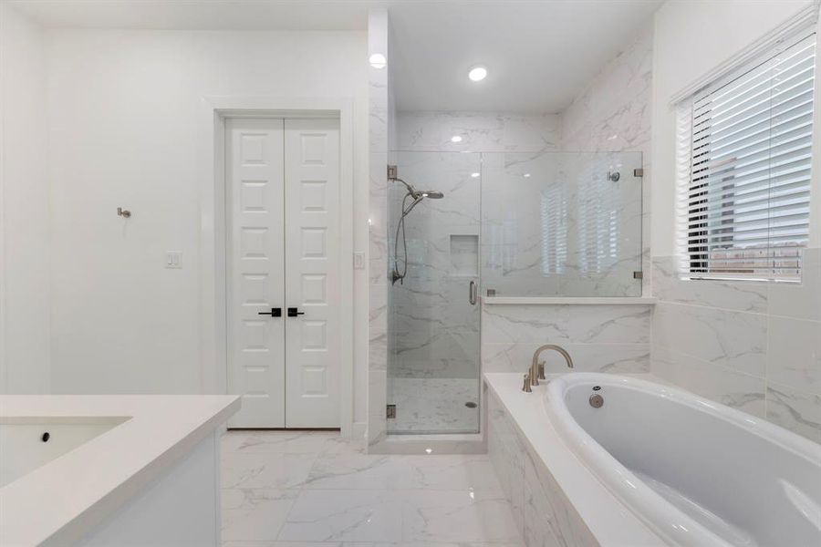 The pristine primary bathroom features a luxurious soaking tub and a separate tile shower, creating a spa-like retreat where you can unwind and rejuvenate.