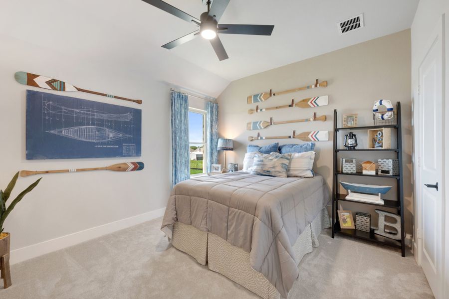 Bedroom with vaulted ceiling, ceiling fan, nautical decor, decorative oars on walls, and a queen bed with blue accents