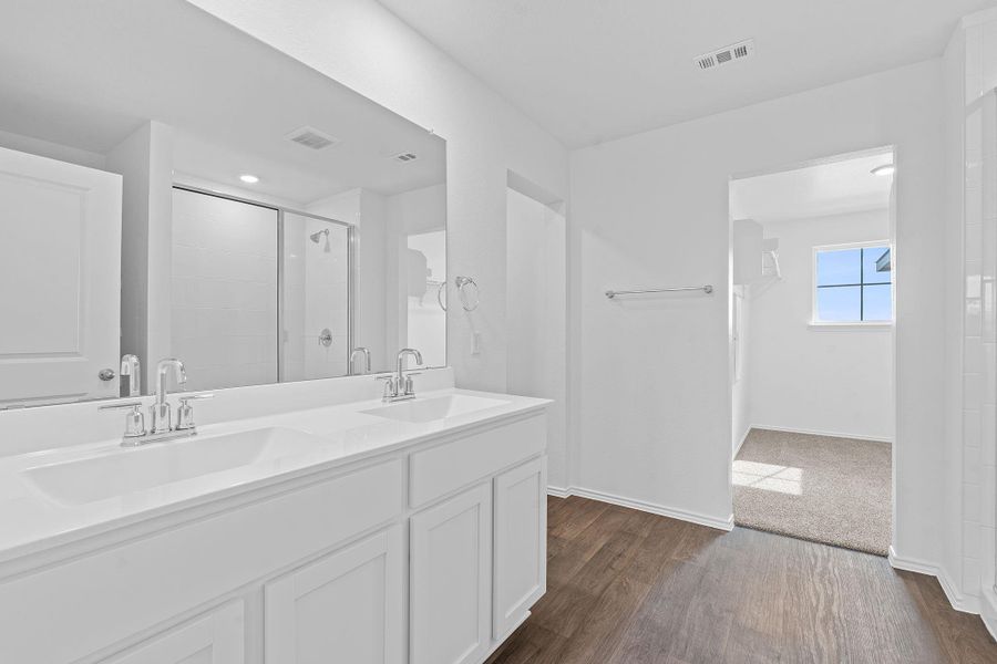Full bathroom with dark wood-style flooring, double vanity, and a shower stall Full bathroom with dark wood-style flooring, double vanity, and a shower stall
