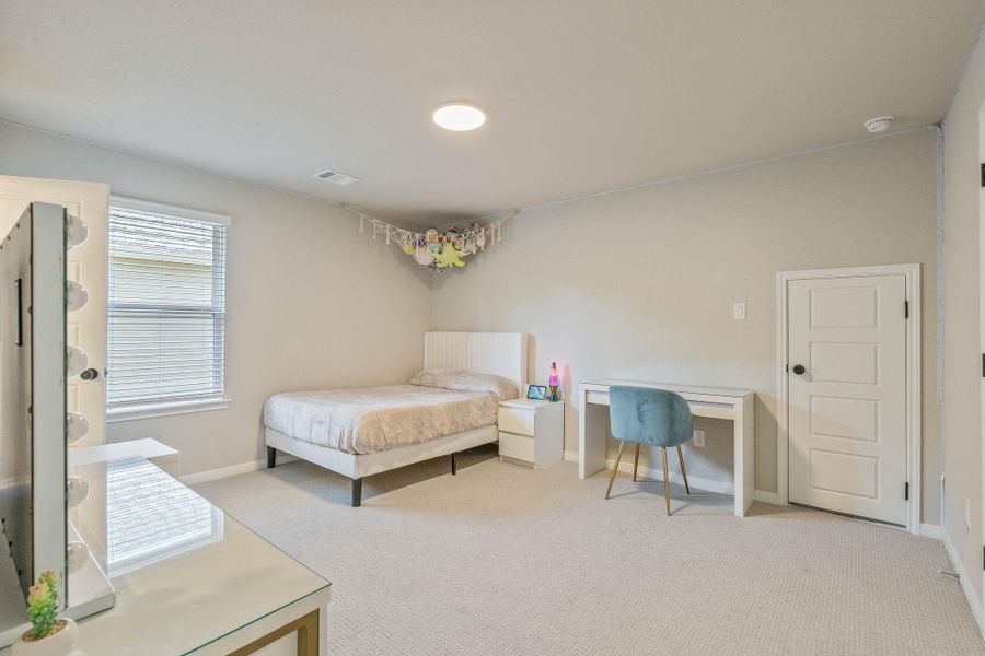 Secondary bright and spacious bedroom featuring neutral walls, plush upgraded carpeting, and a large window that lets in natural light offering a comfortable and functional living space. Secondary bright and spacious bedroom featuring neutral walls, plush upgraded carpeting, and a large window that lets in natural light offering a comfortable and functional living space.