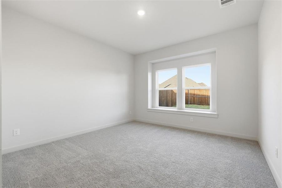 Neutral-toned carpeting and walls complement the natural light entering through the large window Neutral-toned carpeting and walls complement the natural light entering through the large window
