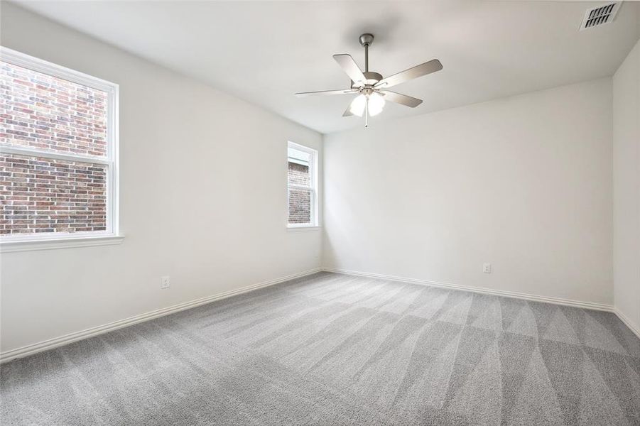 Carpeted empty room with ceiling fan