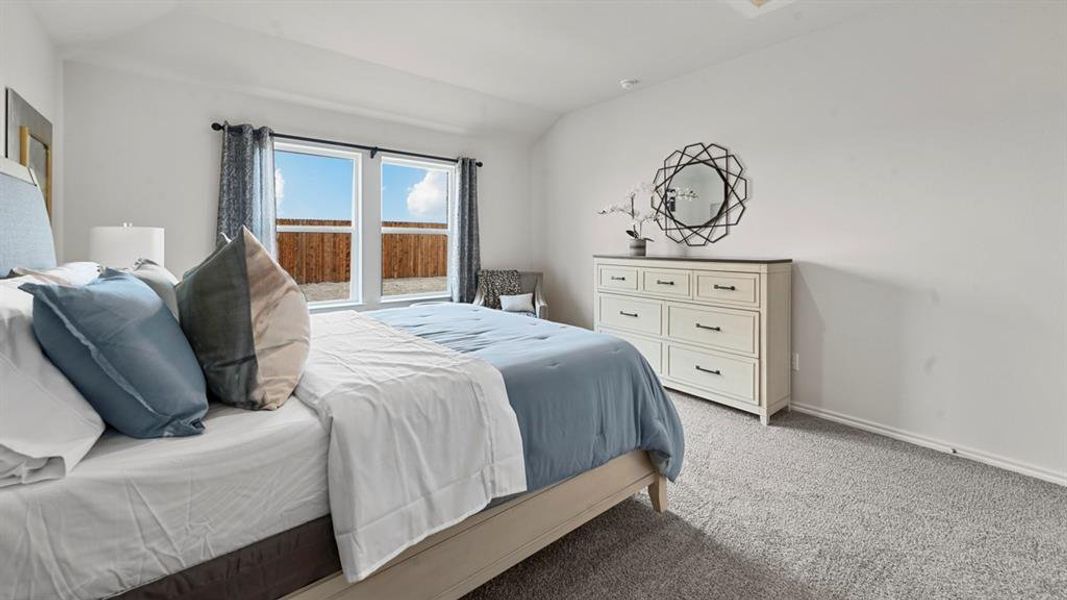 Bedroom featuring vaulted ceiling and light carpet Bedroom featuring vaulted ceiling and light carpet