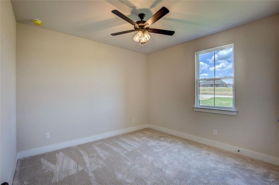 Carpeted spare room with ceiling fan