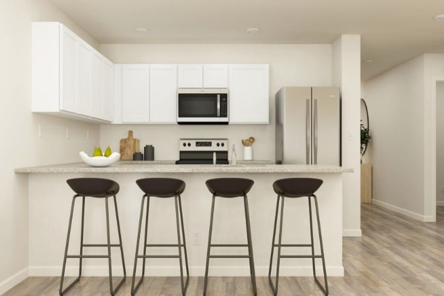 A kitchen with stools and a refrigerator.