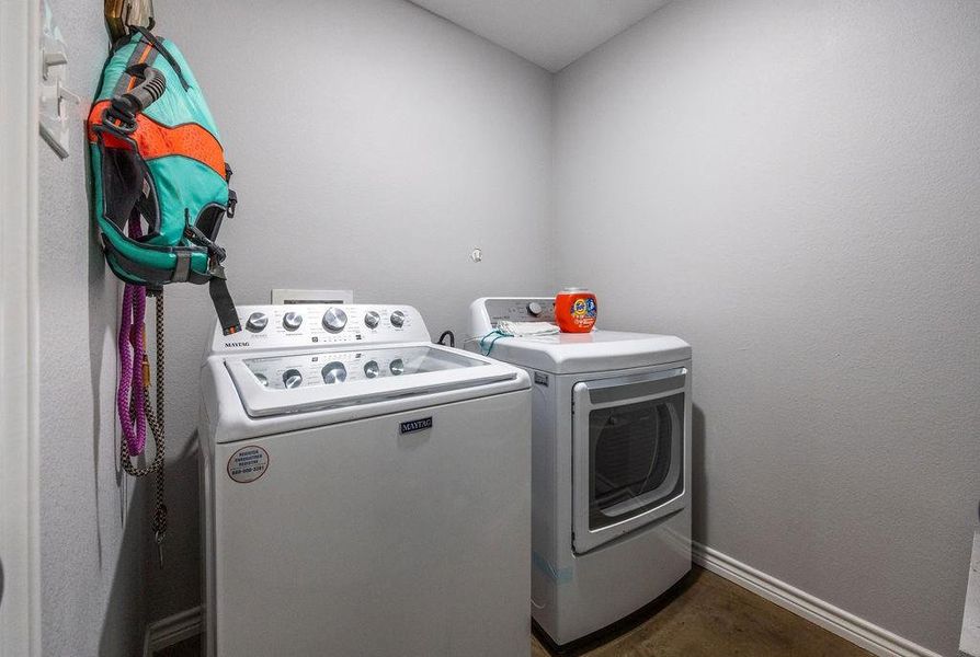 Laundry room featuring baseboards and washer and clothes dryer