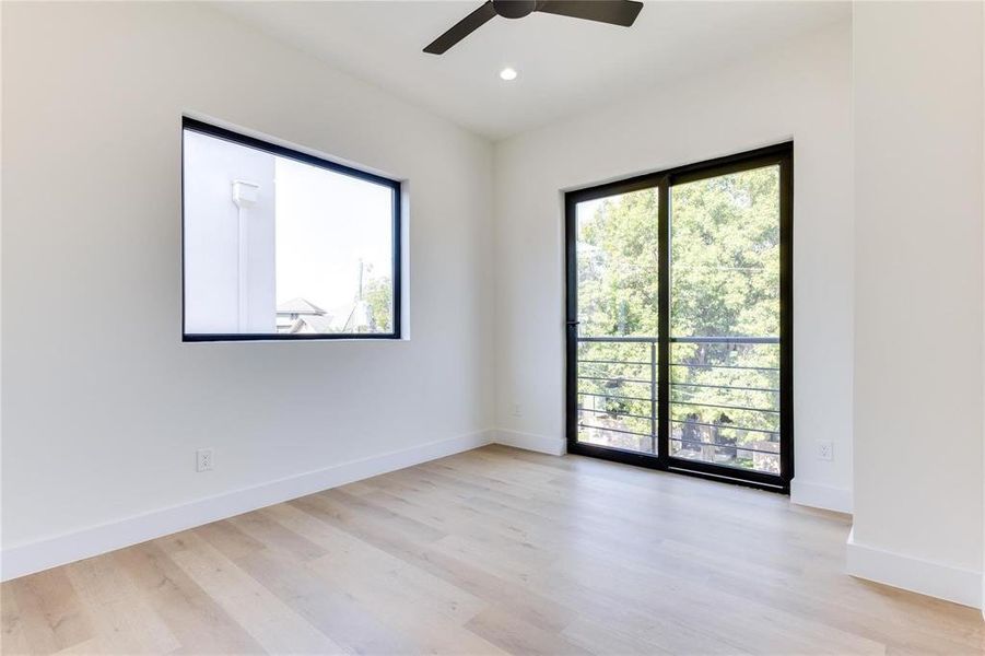 Unfurnished room with ceiling fan, a wealth of natural light, and light wood-type flooring