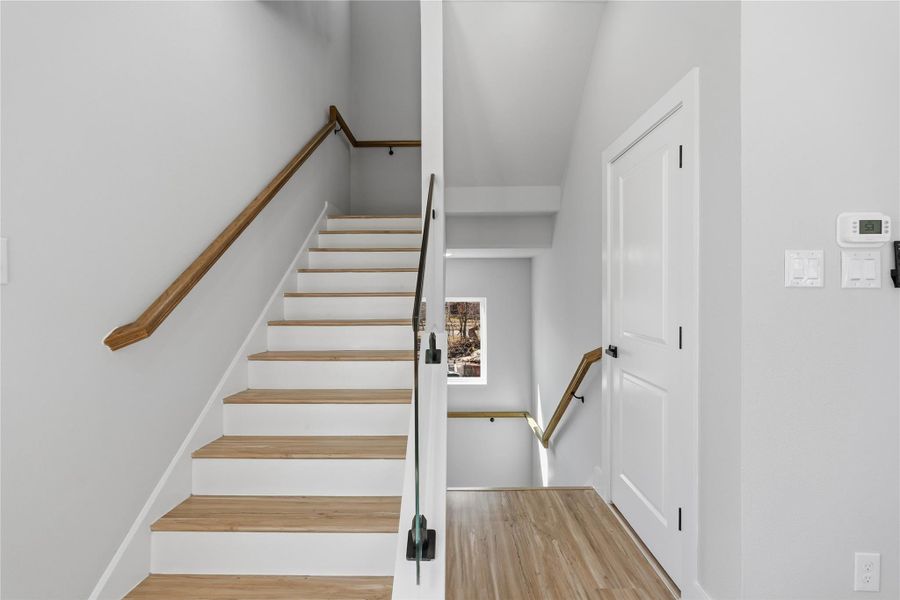 Staircase leading to the third floor with modern railings and wood-accented steps.Thoughtfully designed layout enhances flow between levels with a sleek, contemporary feel.