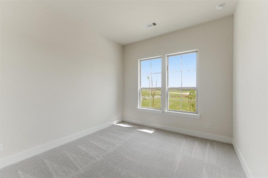 Interior room featuring two large windows, light grey carpeting, white baseboards, light-colored walls, and a recessed ceiling light