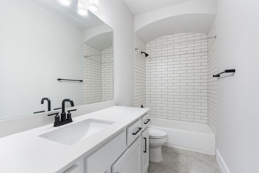 Bathroom featuring shower / washtub combination, vanity, and light tile patterned flooring
