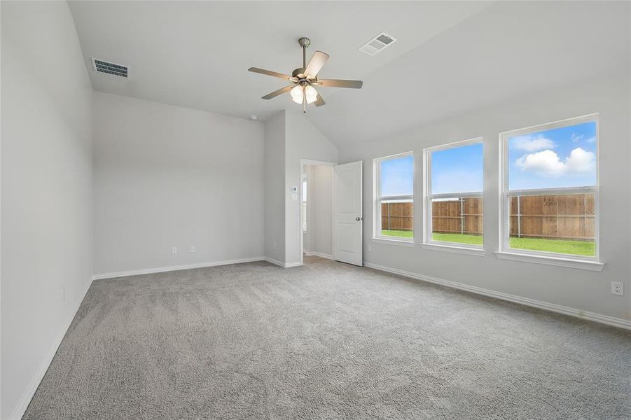 Spare room featuring light carpet, a ceiling fan, and vaulted ceiling Spare room featuring light carpet, a ceiling fan, and vaulted ceiling