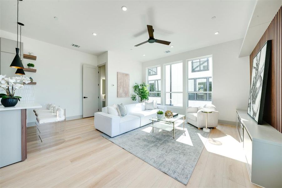 Living room with light hardwood / wood-style flooring and ceiling fan