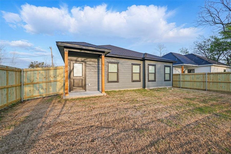 Rear view of property with a fenced backyard and a lawn Rear view of property with a fenced backyard and a lawn
