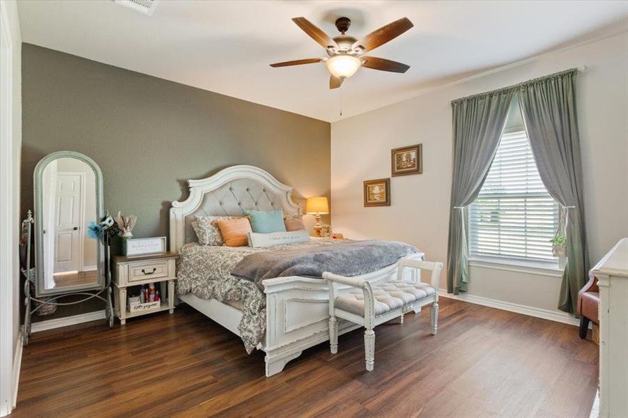 Bedroom with dark wood-style floors and ceiling fan