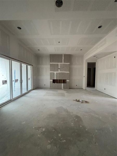 This is the living room where you will have a floor to ceiling stone electric fireplace with built-ins. There will be a cabinet at the bottom with quartz counter and floating shelves above! The floors will be a "wood" like tile or Buyer can choose floors with flooring credit.