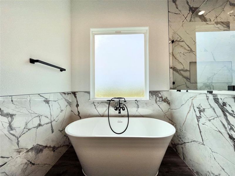 Bathroom with wainscoting, a soaking tub, and tile walls Bathroom with wainscoting, a soaking tub, and tile walls
