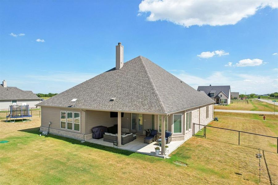 Back of property featuring covered patio and fenced backyard.