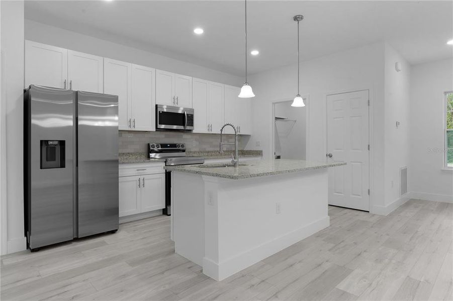 Looking at the kitchen, the open door is the laundry area, that leads to the garage. The closed door is the kitchen pantry closet.