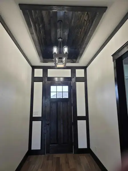 Entrance foyer featuring baseboards and dark wood-style flooring Entrance foyer featuring baseboards and dark wood-style flooring