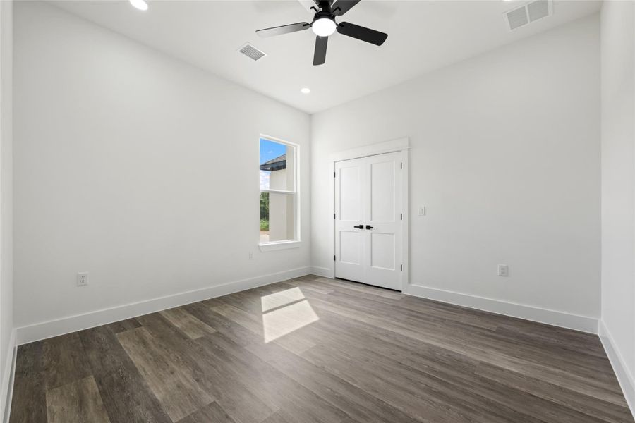 Bright interior space featuring wood-finish flooring, a contemporary ceiling fan, recessed lighting, and a double-panel door with matte black hardware