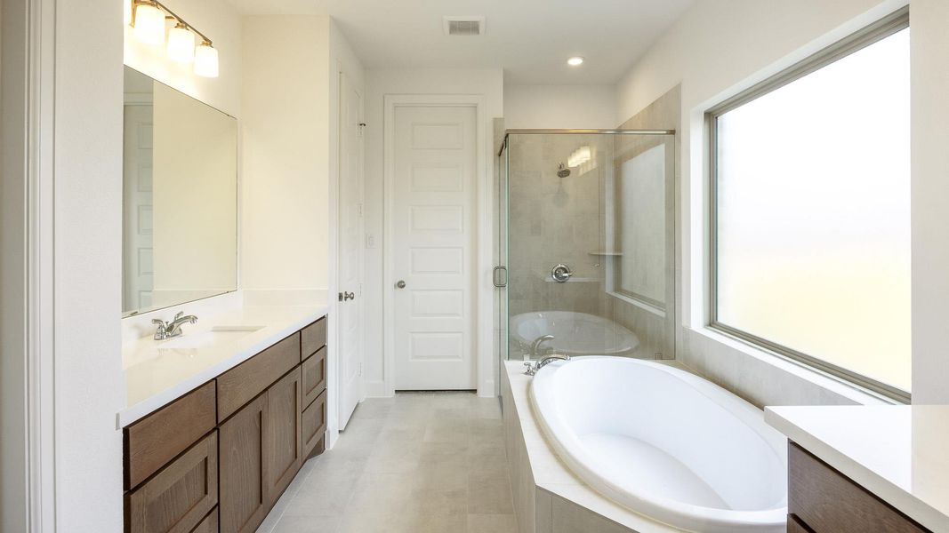 Full bath with vanity, a stall shower, a garden tub, healthy amount of natural light, and recessed lighting