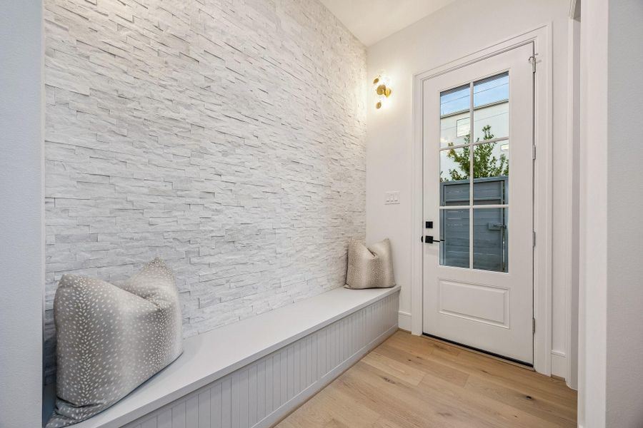 Built-In Bench under the Stairs with a Cosmic White Stacked Stone Wall and Two Possini Euro Filoli 16" High Wall Sconces.