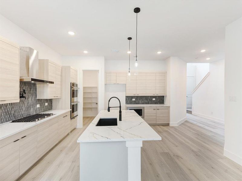 Kitchen with backsplash, light brown cabinets, light stone counters, and recessed lighting Kitchen with backsplash, light brown cabinets, light stone counters, and recessed lighting