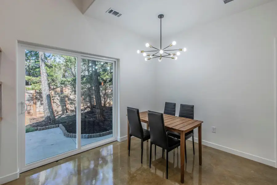 Dining room featuring finished concrete floors, a chandelier, and lofted ceiling
